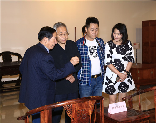IMG_0836遵化市龍?jiān)垂に嚬べQ(mào)有限責(zé)任公司董事長(zhǎng)王澤林（左一）向中華木工委主任趙夫瀛先生（左二）介紹改良版&ldquo;黃花梨皇宮椅&rdquo;_副本